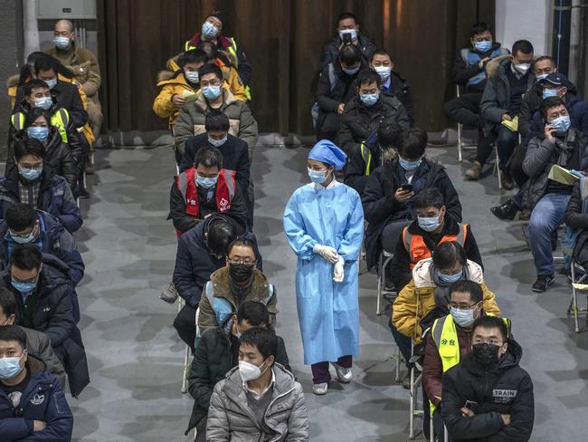 Chinese workers, including security guards, wait to receive a COVID-19 vaccine jab in Beijing. Picture: Getty Images.