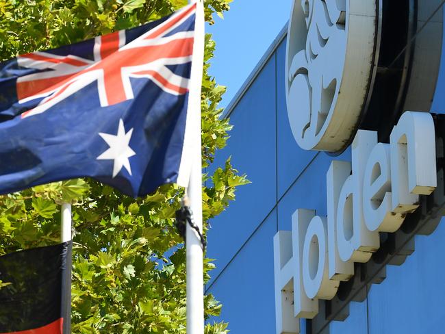 Holden Signage is seen behind an Australian flag and an Australian Aboriginal flag outside the GM-Holden headquarters in Melbourne, Monday, February 17, 2020. General Motors has decided to retire the Holden brand in both Australia and New Zealand. (AAP Image/James Ross) NO ARCHIVING