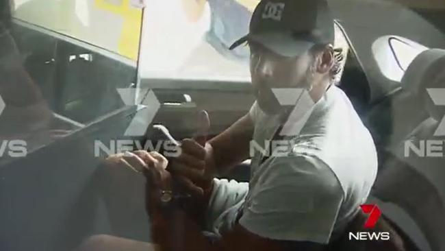 Grant Hackett appeared to give a thumbs-up as he was taken away in handcuffs. Picture: Channel Seven