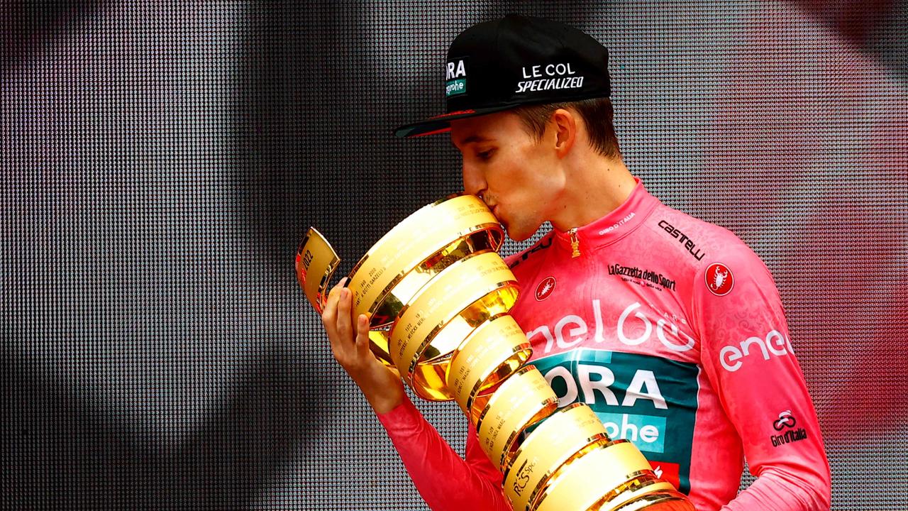 Team Bora's Australian rider Jai Hindley kisses the "Trofeo Senza Fine" race winner's trophy on the podium after winning the Giro dâ&#128;&#153;Italia 2022 cycling race in Verona on May 29, 2022. (Photo by Luca Bettini / AFP)
