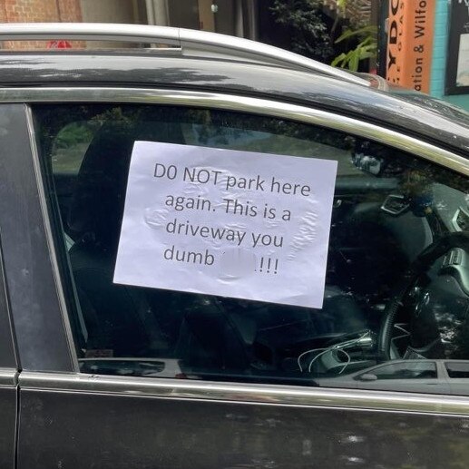 An illegal park, blocking a driveway, in the inner west. The blurred word left by an angry resident rhymes with "cluck". Picture: Supplied