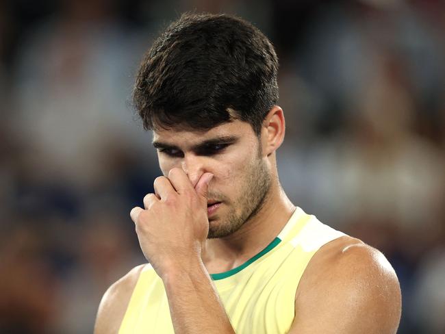 Spain's Carlos Alcaraz reacts as he plays against Germany's Alexander Zverev during their men's singles quarter-final match on day 11 of the Australian Open tennis tournament in Melbourne on January 24, 2024. (Photo by Martin KEEP / AFP) / -- IMAGE RESTRICTED TO EDITORIAL USE – STRICTLY NO COMMERCIAL USE --