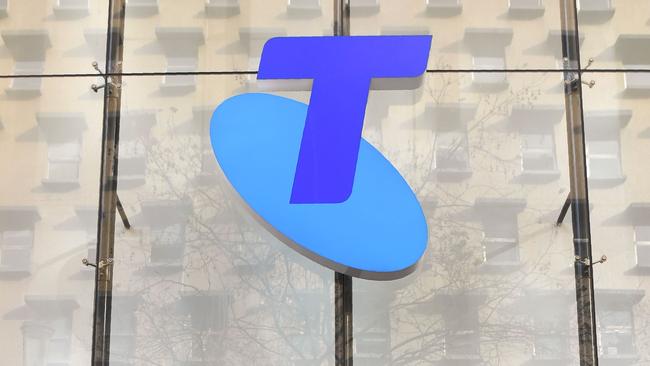 A man speaks on his phone as he walks past a Telstra store on Melbourne's central business district on June 20, 2018. Australia's dominant telecommunications company Telstra on June 20 announced plans to axe 8,000 jobs -- a quarter of its workforce -- as part of a drastic new strategy to cope with an increasingly competitive industry.  / AFP PHOTO / William WEST