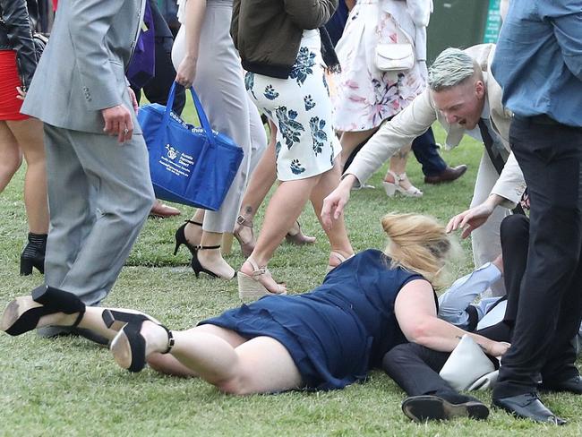 The move doesn’t work as anticipated and the pair end up on the grass, helped by a blond friend in a beige suit amid other racegoers. Picture: Getty.