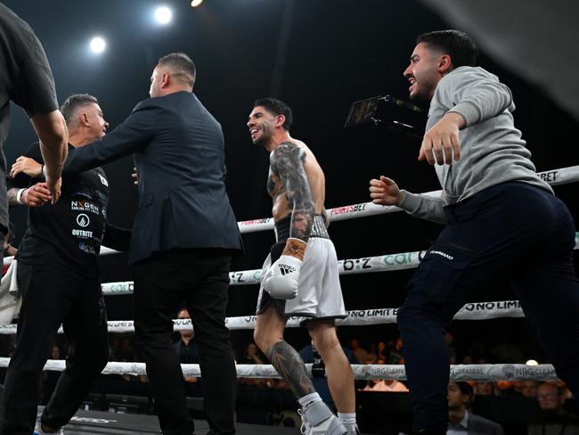 Michael Zerafa’s brother (grey shirt) moments before he punched Tommy Mercuri (left) in the face. Pictures: No Limit Boxing/Gregg Porteous