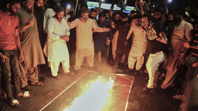 Pakistani protesters burn an Indian flag after the strikes. Picture: Pervez Masih/AP
