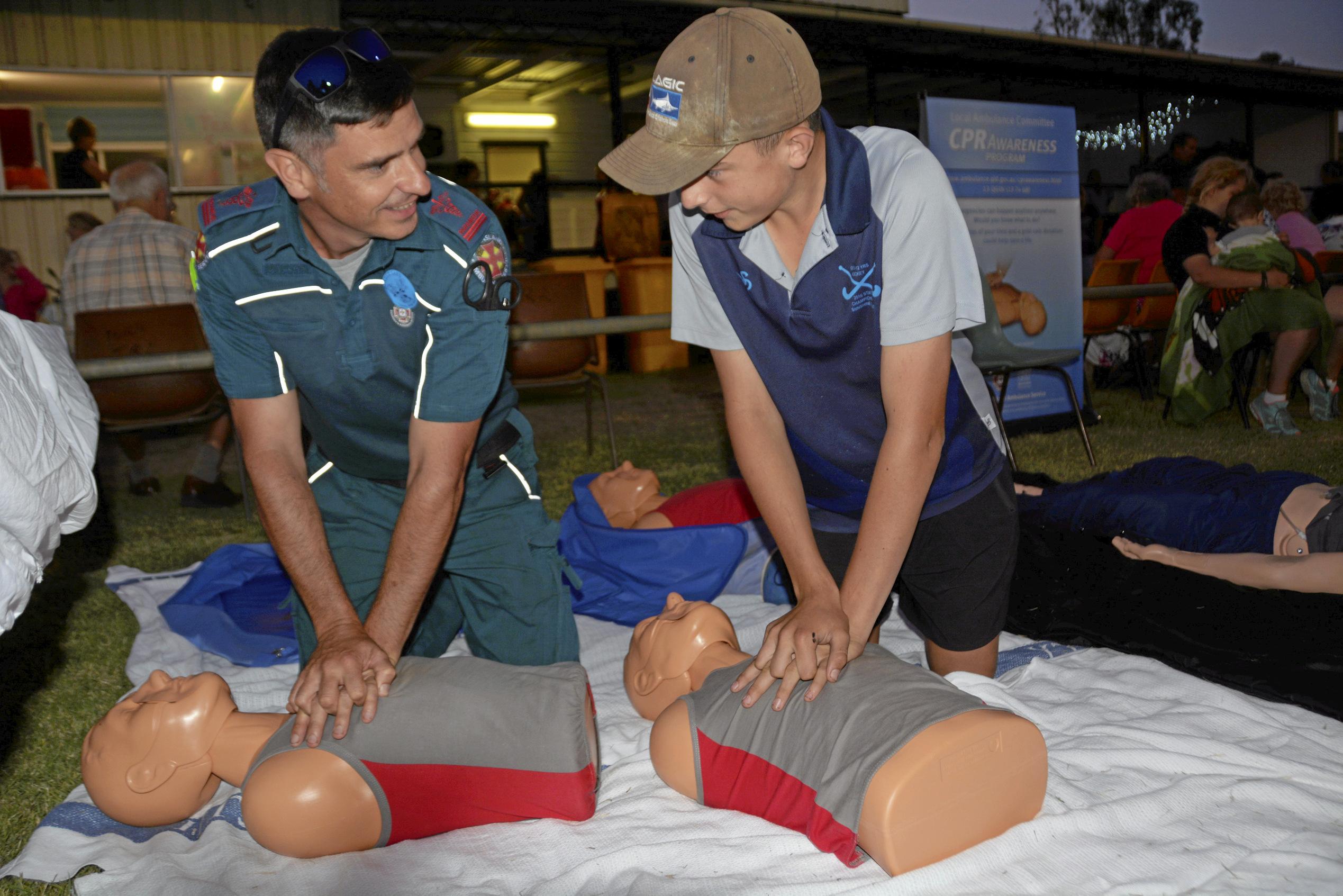 Tara paramedic David Hornsby shows his son Jamie Hornsby, 14 CPR at the Tara Christmas Carnival 081218. Picture: Eloise Quinlivan