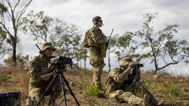 Australian Army Gunner Emmanuel Gomapas (left) and Bombardier Michael Neilson (right), from the 4th Regiment, Royal Australian Artillery, observe a target position as Royal Australian Air Force Flight Lieutenant Ebrahim Tabandeh monitors the airspace during Exercise Nigrum Pugio at Townsville Field Training Area on 14 October 2020.