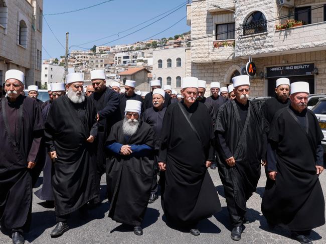 Druze elders and mourners surround the coffin of Guevara Ibrahim, 11, killed in a rocket strike two days earlier. Picture: AFP