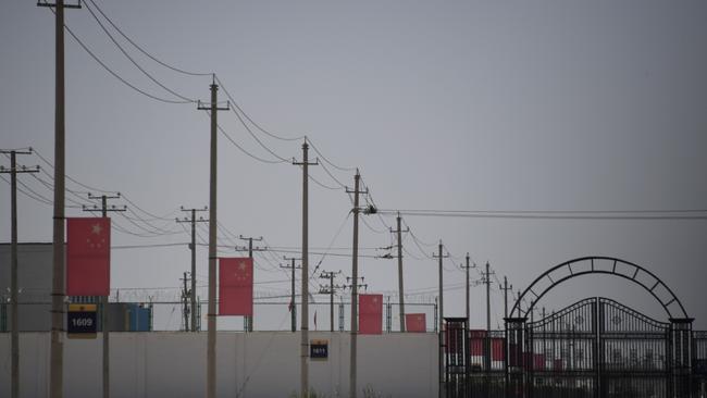 A file photo taken on May 31, 2019 shows Chinese flags on a road leading to a facility believed to be a re-education camp where mostly Muslim ethnic minorities are detained, on the outskirts of Hotan in China's northwestern Xinjiang region. Picture: Greg Baker/AFP