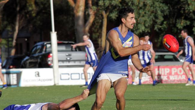 Ouyen's Luke Stanbrook clings onto Irymple's Nando Cirillo as he fires off a handball. Picture: Glenn Milne