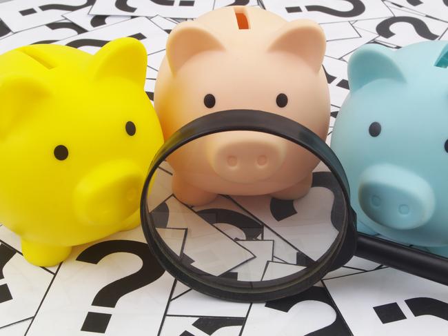 Three piggy banks under magnifying glass on question marks background. Saving money concept; superannuation saving generic