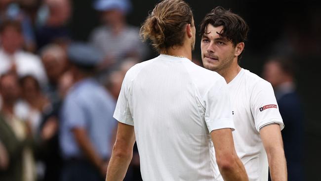 Taylor Fritz (rear) speaks with Germany's Alexander Zverev. Photo by HENRY NICHOLLS / AFP.