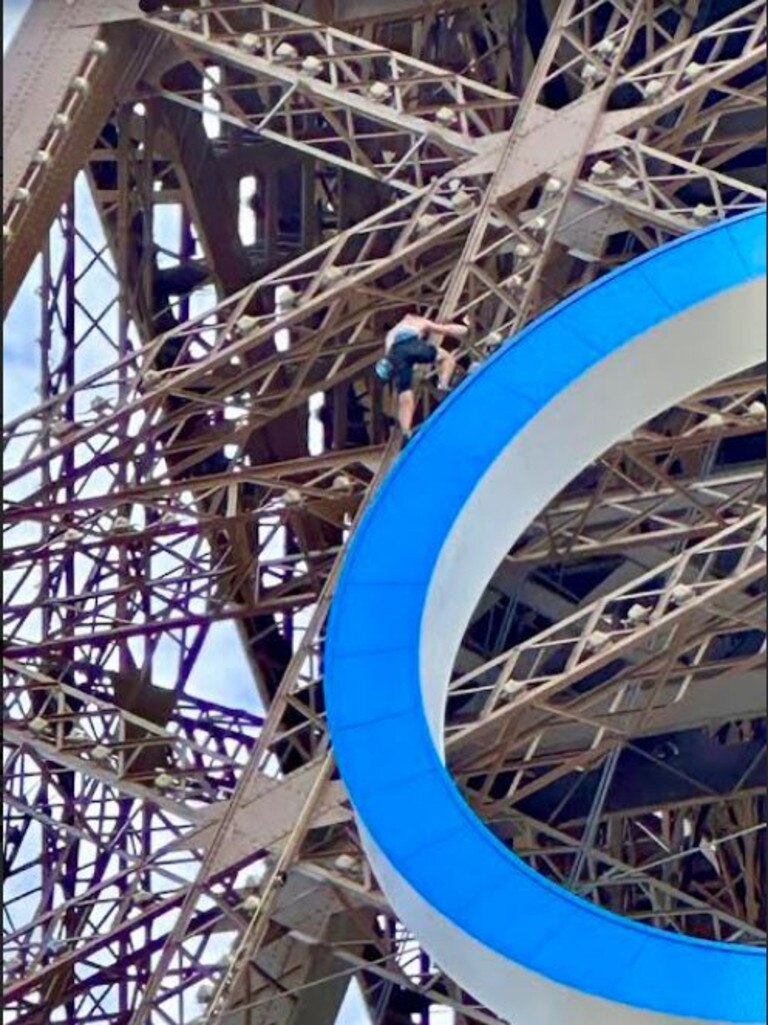 The shirtless man climbs the Eiffel Tower just hours before the closing ceremony begins. Picture: X