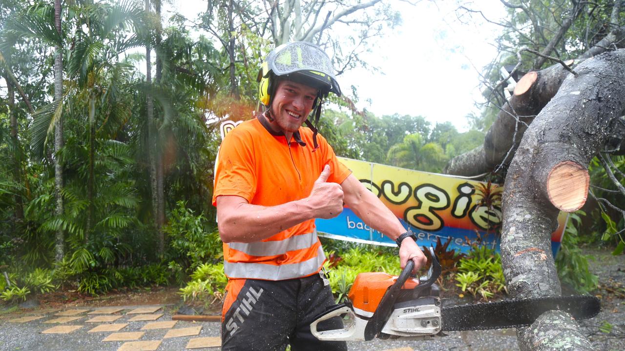 Harry Thomas removes a fallen tree downed by Cyclone Jasper outside Dougies Backpackers Resort in Port Douglas. Picture: Peter Carruthers