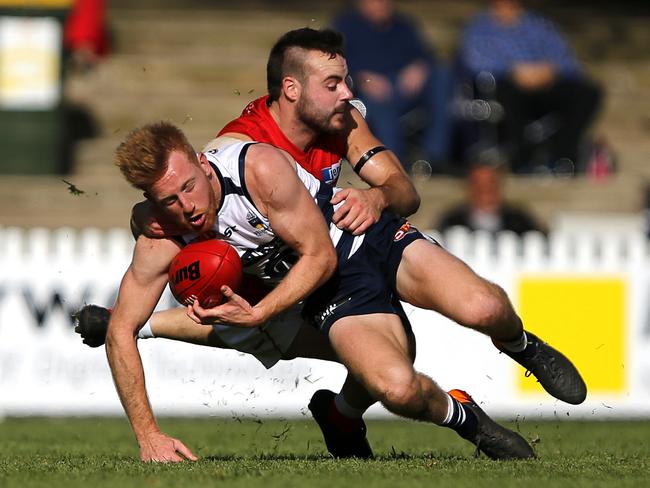 Nick Liddle, a standout for South Adelaide, is challenged for the ball by North Adelaide skipper Max Thring. Picture: Deb Curtis