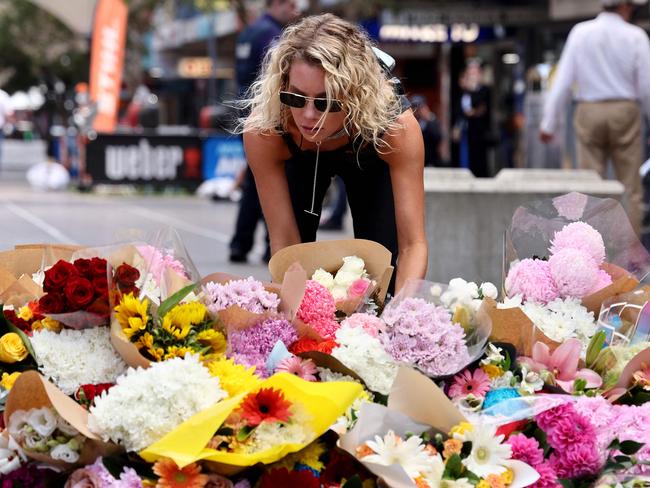 A woman leaves flowers outside the Westfield Bondi Junction shopping mall in Sydney on April 14, 2024, the day after a 40-year-old knifeman with mental illness roamed the packed shopping centre killing six people and seriously wounding a dozen others. (Photo by DAVID GRAY / AFP)