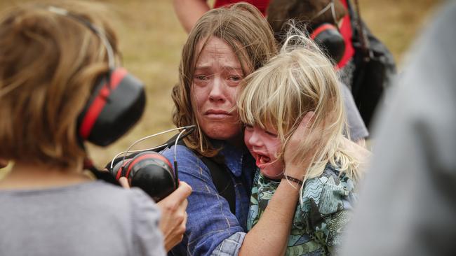 A distressed mum covers her daughter’s ears before the evacuation. Picture: David Caird