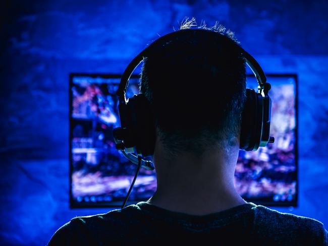 Men wearing headphones playing video games late at night Picture: Istock