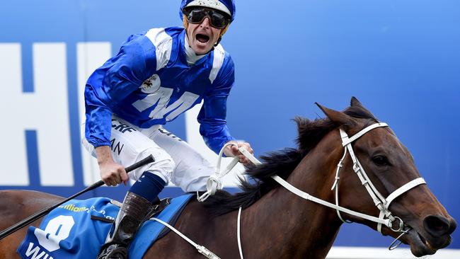 Hugh Bowman celebrates after Winx destroyed her rivals in the Cox Plate. Picture: Nicole Garmston