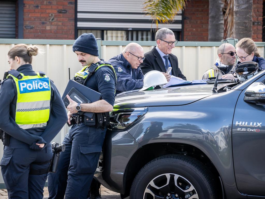 Officers gather outside the property. Picture: Jake Nowakowski