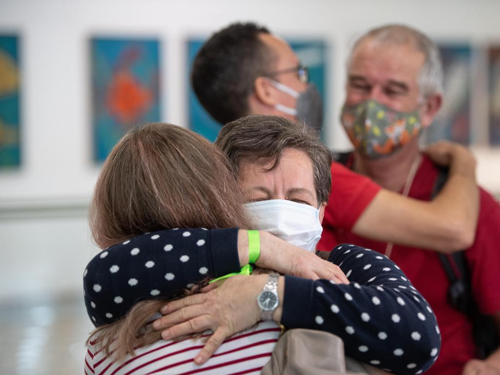 Zsofi Nemeth hugs mum Julianna Nemeth in front of Rudolf Nemeth hugs son-in-law David Kaity at Brisbane International airport as borders re-open. Picture: Brad Fleet