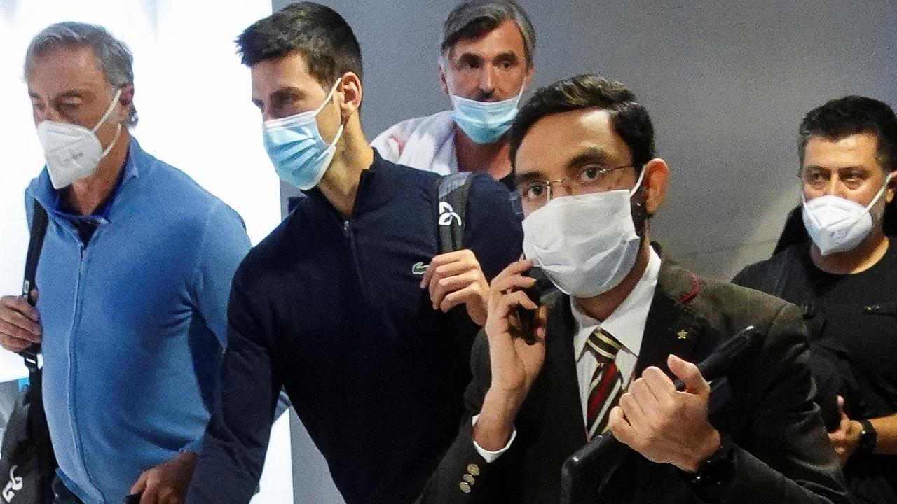 Novak Djokovic walks with his team after landing at Dubai Airport after being deported