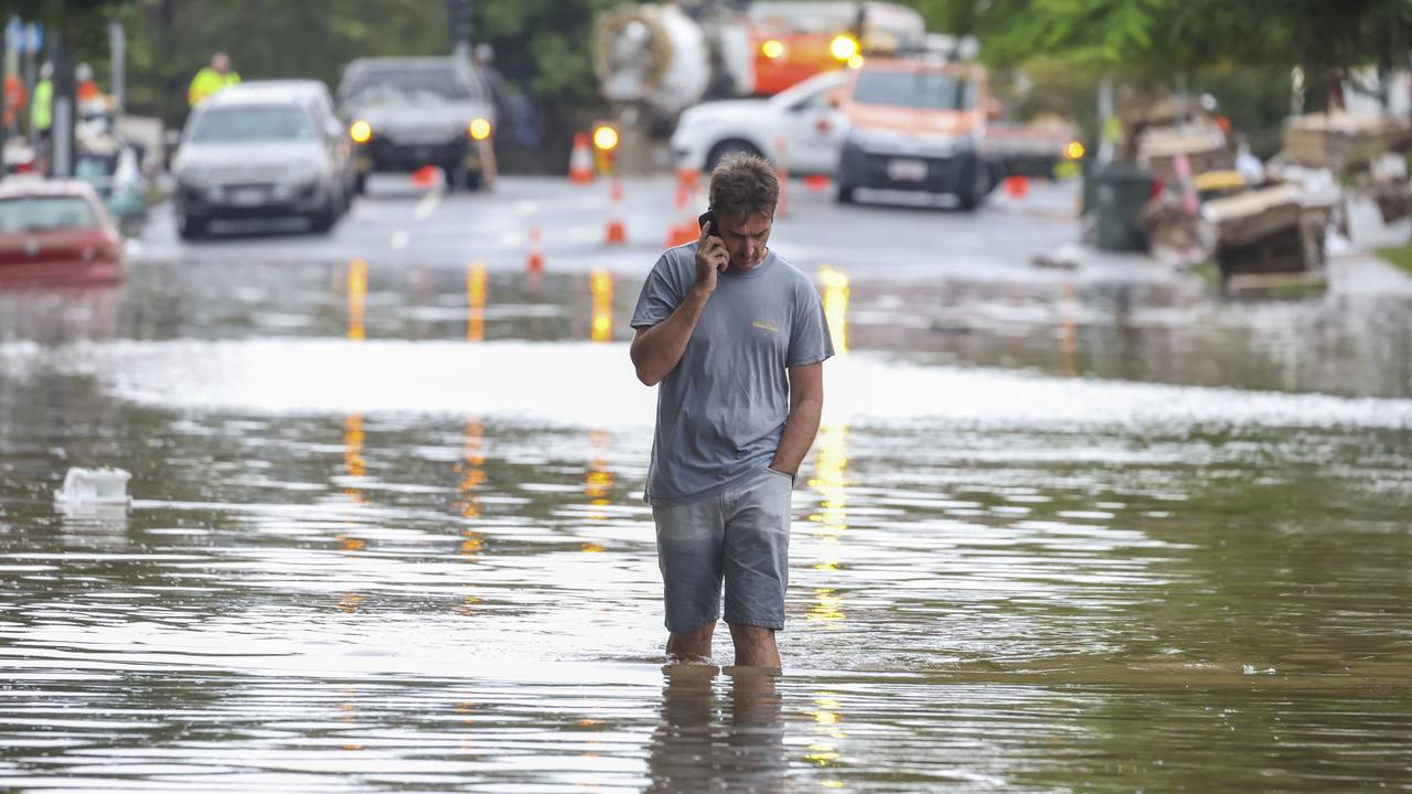 A man walks through floodwaters at Torwood Street, Auchenflower. Picture: Peter Wallis