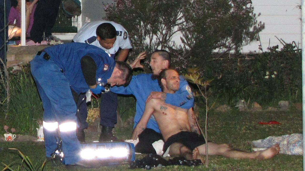 Paramedics treat Robert Leuthwaite Jr for a bullet wound to the chest in the front yard of his home in Werrington, western Sydney, on August 22, 2010.