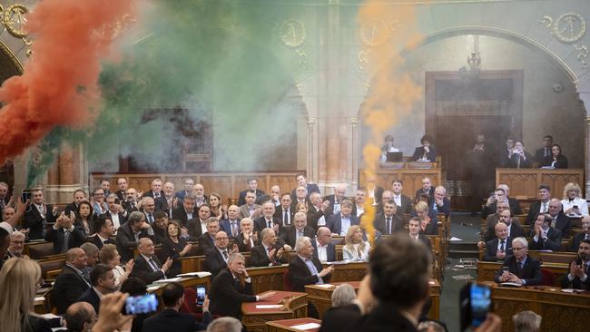 Opposition MPs light flares in parliament to protest against the Pride ban. Picture: AP.