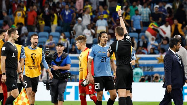 German referee Daniel Siebert presents a yellow card to Uruguay's forward Edinson Cavani after the end of their match against Ghana. Picture: AFP