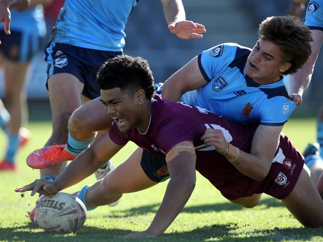 QLD's Karl Oloapu scores a try whilst NSW's Chevy Stewart attempts to tackle during the under 18 ASSRL schoolboy rugby league championship grand final between QLD v NSW CHS from Moreton Daily Stadium, Redcliffe. Picture: Zak Simmonds