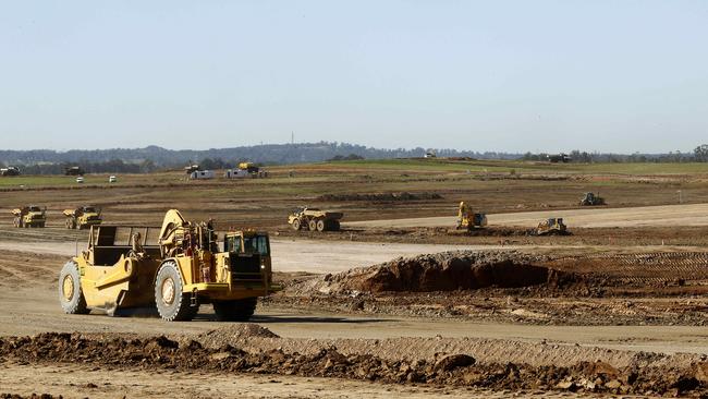 Earthmovers carve out the runway as works continue at the Badgerys Creek Construction site of the Western Sydney Airport. Picture: John Appleyard