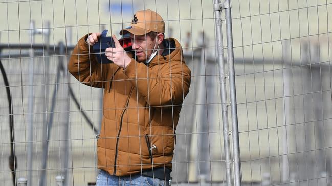 Fans watch from behind a fence during the round 19 AFL match between Western Bulldogs and Adelaide Crows at Mars Stadium Picture: Getty Images