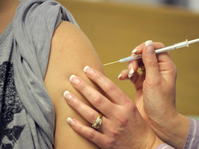 28 year-old Tara Seaton, an Australia Post employee, looks away as Luiza Duszynski, a nursing supervisor at the Royal Adelaide Hospital, injects her with CSL Ltd.'s H1N1 vaccine in Adelaide, Australia, on Wednesday, July 22, 2009. The first human trials of a swine-flu vaccine began today in Australia as deaths and infections from the H1N1 virus mount worldwide, intensifying demand for a protective shot. Photographer: Carla Gottgens/Bloomberg