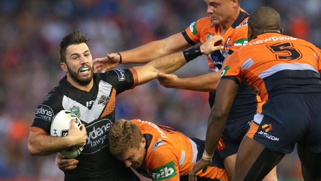 NEWCASTLE, AUSTRALIA - APRIL 10: James Tedesco of the Tigers is tackled by Trent Hodkinson of the Knights during the round six NRL match between the Newcastle Knights and the Wests Tigers at Hunter Stadium on April 10, 2016 in Newcastle, Australia. (Photo by Tony Feder/Getty Images)