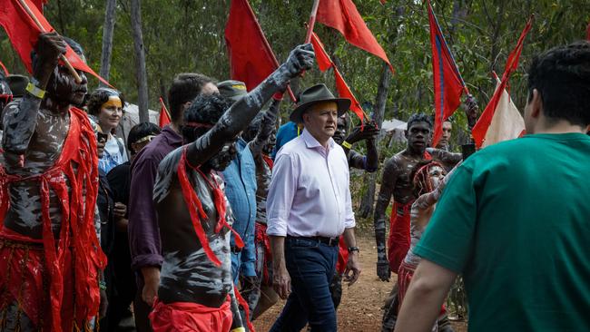 Anthony Albanese is escorted through the Garma Festival camp site by the Red Flag Dancers in August 2023 in East Arnhem. Picture: Tamati Smith,Getty Images