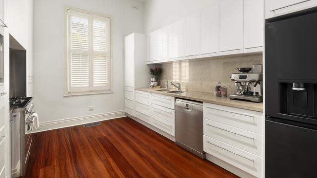 The kitchen and adjacent laundry are equipped with European appliances.