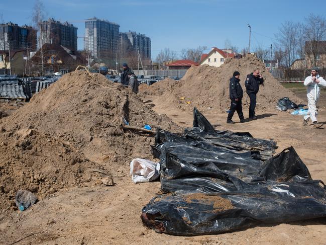 The bodies exhumed from the mass grave lie on the ground in Bucha, Ukraine. The Russian retreat from Ukrainian towns and cities has revealed scores of civilian deaths. Picture: Getty Images