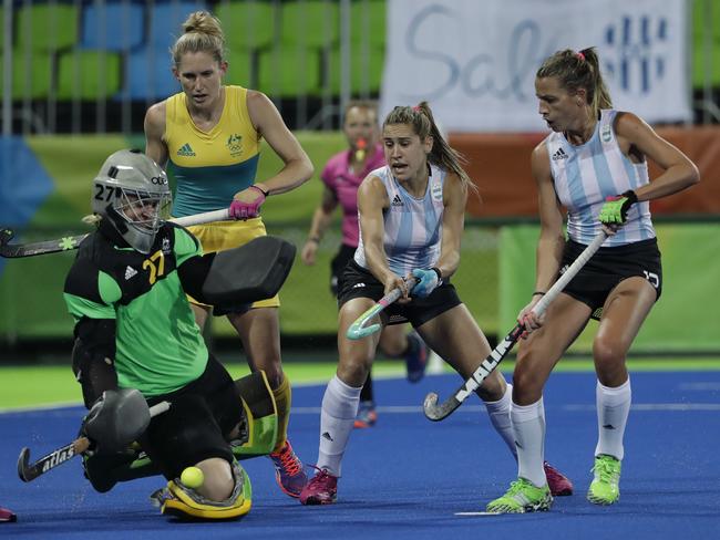 Australia's goalkeeper Rachael Lynch, left, saves the ball against Argentina's Martina Cavallero, center, and Argentina's Delfina Merino, right, during a women's field hockey match at 2016 Summer Olympics in Rio de Janeiro, Brazil, Thursday, Aug. 11, 2016. (AP Photo/Hussein Malla)