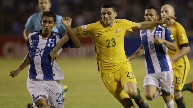 Jorge Claros fights for the ball with Tom Rogic in San Pedro Sula.