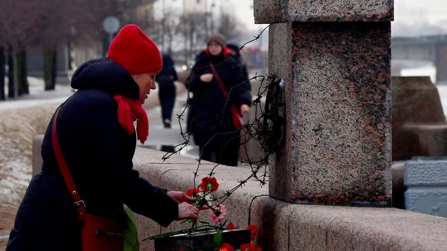 A woman lays flowers at the Memorial to Victims of Political Repression to pay respect to Alexei Navalny in Saint Petersburg. Picture: AFP