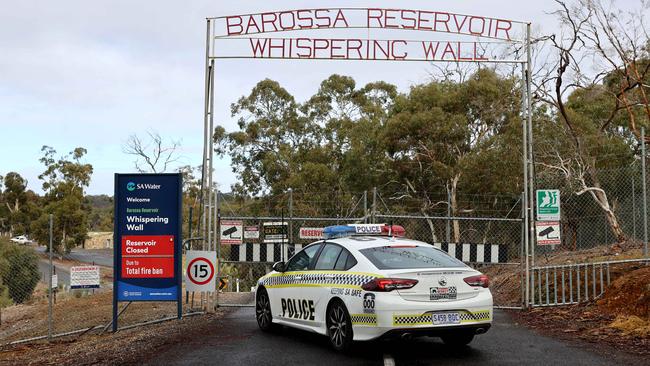 Police at the gate of the Whispering Wall, Barossa Reservoir where Henry Shepherdson jumped to his death holding his daughter Kobi. Picture: Kelly Barnes