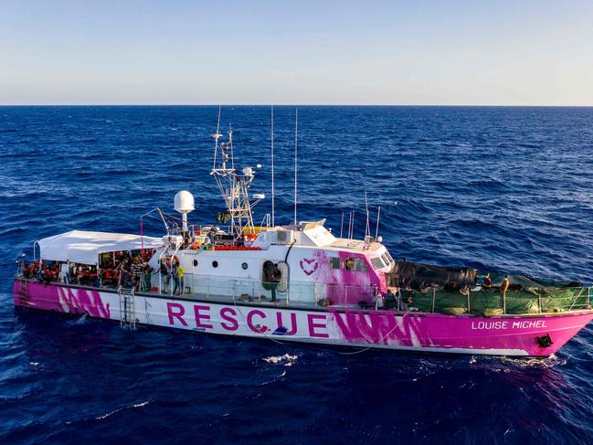 The rescue ship funded by British street artist Banksy "Louise Michel" is pictured during a rescue operation by crew members of civil sea rescue ship Sea-Watch 4 off the coast of Malta, on August 29, 2020. - An Italian coastguard vessel on August 29, 2020 had rushed to "Louise Michel" after it sent out a call for help with more than 200 migrants onboard, and took in 49 of the most vulnerable people on board. The Sea-Watch 4 vessel, that has a clinic and already rescued 201 migrants onboard and is itself in search of a host port, also arrived and took over 150 migrants from "Louise Michel". (Photo by Thomas Lohnes / AFP) / Germany OUT