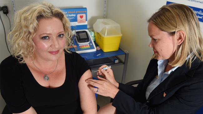 (Health Minister Jill Hennessy gets a flu shot from pharmacist Zoe Escott. Picture: Josie Hayden