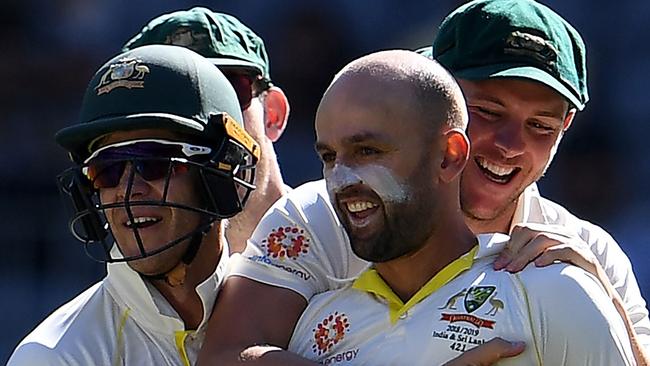 Australia's bowler Nathan Lyon (C) is congratulated by teammates after dismissing India's captain Virat Kohli during day four of the second Test cricket match between Australia and India in Perth on December 17, 2018. (Photo by WILLIAM WEST / AFP) / -- IMAGE RESTRICTED TO EDITORIAL USE - STRICTLY NO COMMERCIAL USE --