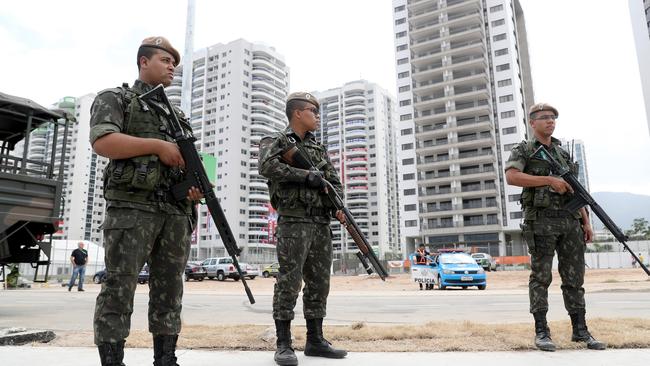 Armed police stand guard outside the Olympic Athletes Village