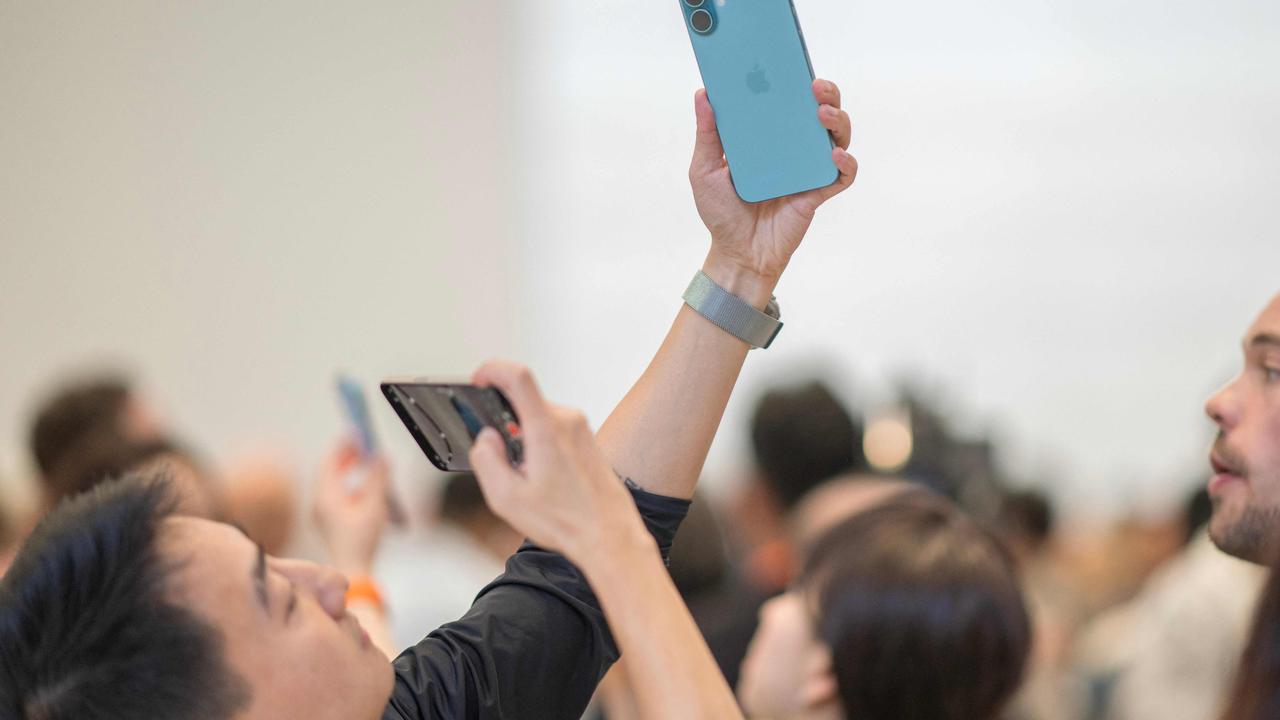 A man takes a photo of an iPhone 16 Pro following Apple's "It's Glowtime" event in Cupertino, California, September 9, 2024. (Photo by Nic COURY / AFP)