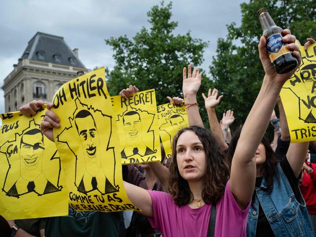 Demonstrators hold placards with illustrated caricature portraits of Jordan Bardella, including one reading “Oh Hitler, how you have long teeth” during a rally at Place de la Republique. Picture: AFP