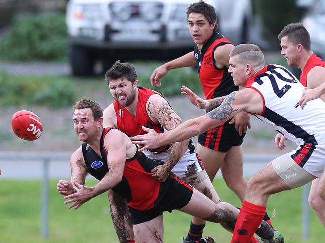 Braden Bayly (Morphett Vale) handballs during the first quarter. Morphett Vale v Flagstaff Hill, at Morphett Vale Oval. Southern Football League. 30/07/16  Picture: Stephen Laffer